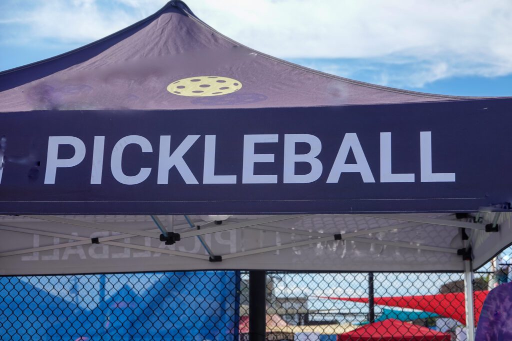 A tent that says pickleball and has a pickleball logo