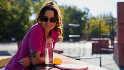 Cheerful pickleball player resting on a sports ground after the game